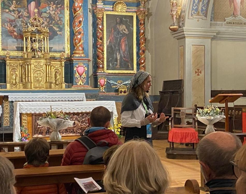 Une guide en costume d'époque dans une église. Escapades baroques dans les Alpes avec la Fondation Facim