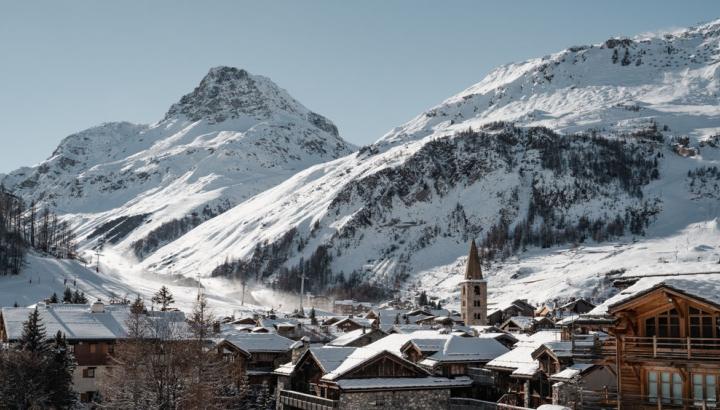 Le village - Val d'Isère - Le village se dessine en premier plan de cette photo avec ses bâtiments en pierre si typique. Derrière le village se dessine le magnifique domaine skiable sous la neige.