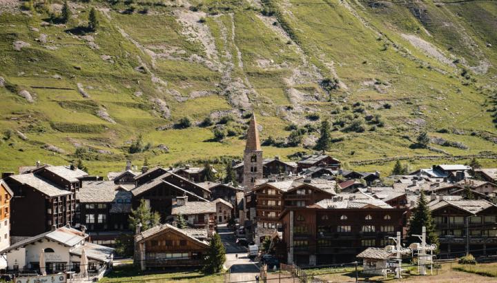 Le village - Val d'Isère - Vue imprenable sur le village de Val d'Isère en été. Les maisons en pierres et en bois ressortent sur les fond vert des montagnes.