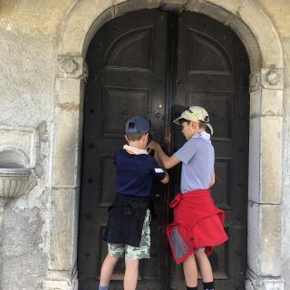 deux enfants ouvrent la porte d'une église
