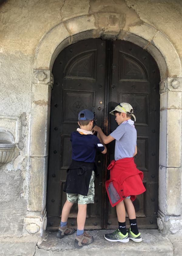 deux enfants ouvrent la porte d'une église