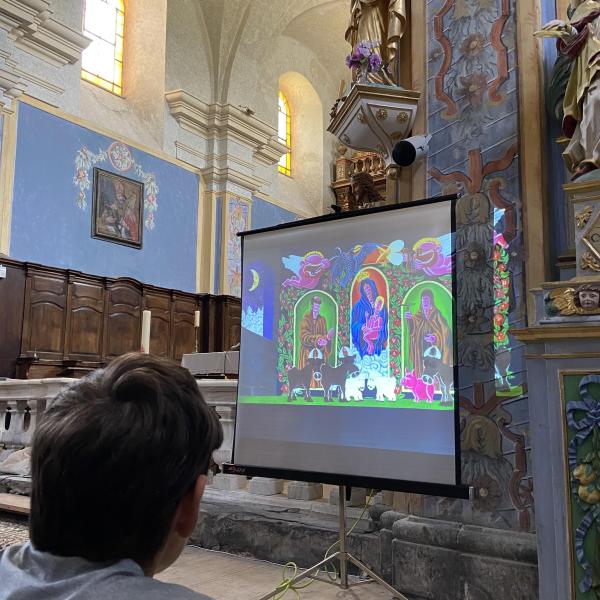 Un enfant regarde la projection du conte Nuit d'or.  Escapades baroques dans les Alpes avec la Fondation Facim