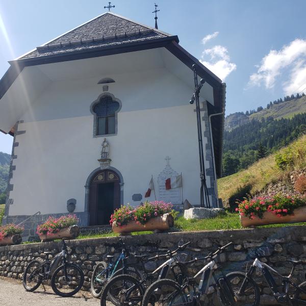 Des VTT devant une chapelle dans le Val d'Arly. Escapades baroques dans les Alpes avec la Fondation Facim